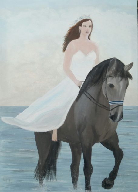 Vrouw in een witte jurk die op een zwart paard aan de kust staat.