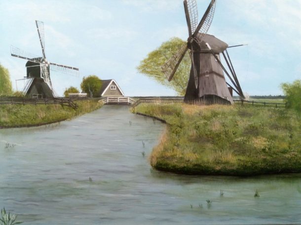 Twee molens langs een rustig water met groene begroeiing en een huisje op de achtergrond.