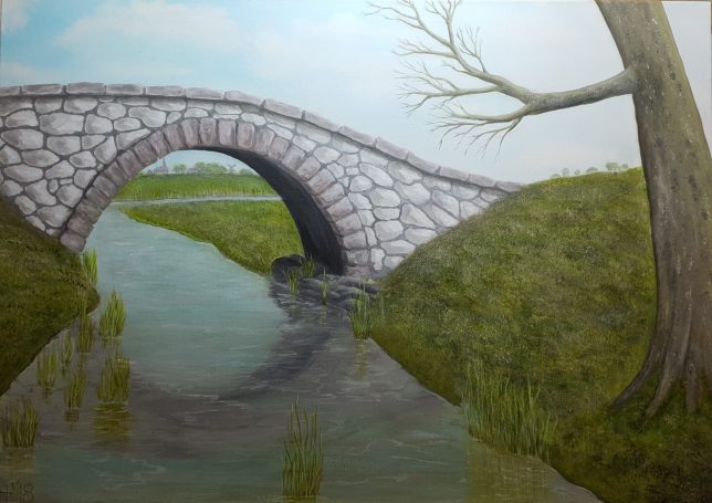 Een stenen brug overspant een rustige stroom, omringd door gras en bomen.